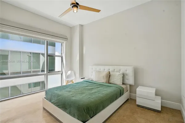 a bedroom with a bed and a flat tv screen on wall