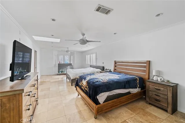 a spacious bedroom with a bed and a flat screen tv