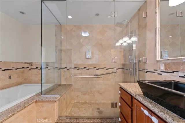 a bathroom with a granite countertop sink a mirror and a shower