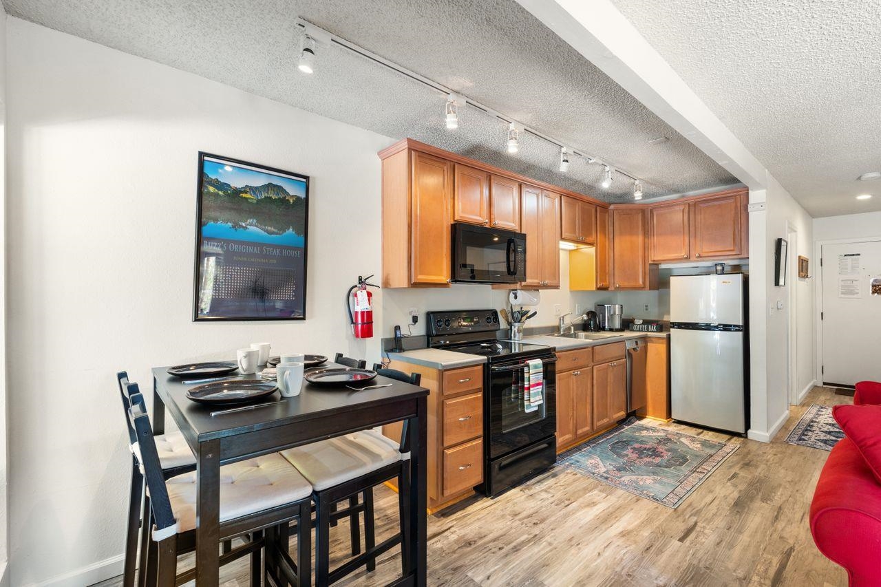 1300 Regency Way, Unit 62 Tahoe Vista, CA 96148 - Photo 5 of 26 a kitchen with granite countertop a refrigerator stove microwave and cabinets