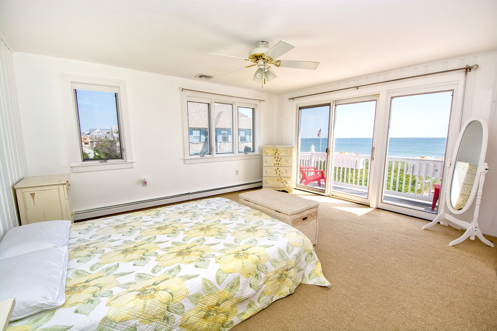 98 Humarock Beach Scituate, MA 02047 - Photo 14 of 14 a spacious bedroom with a large bed and a chandelier