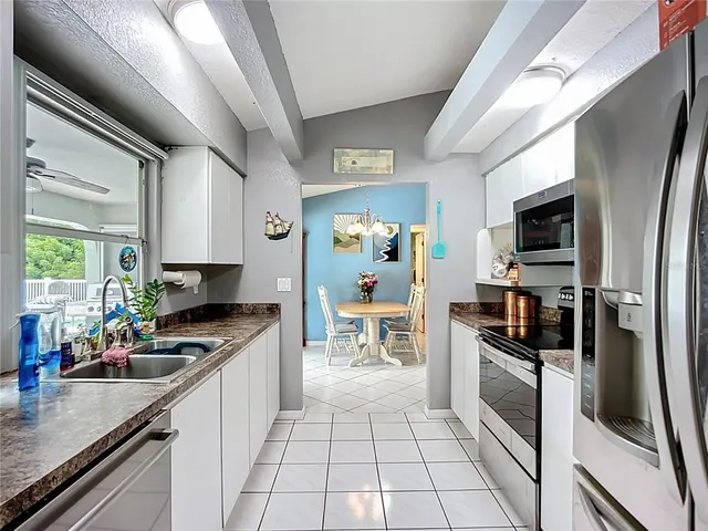 a kitchen with stainless steel appliances granite countertop a refrigerator and a stove top oven