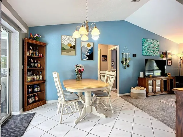 a view of a dining room with furniture and a chandelier