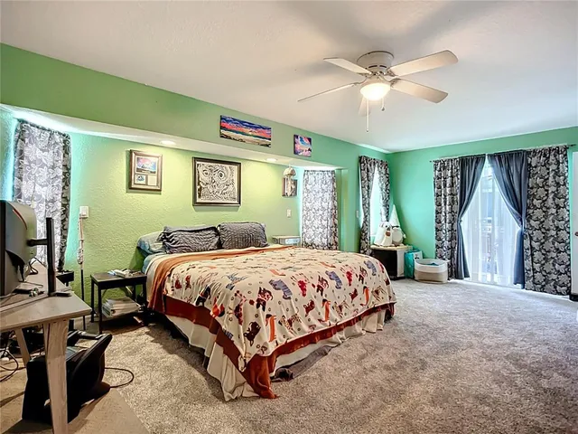 a spacious bedroom with a bed a table and a large window