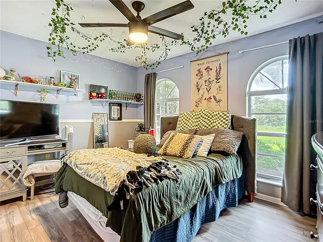 a bedroom with a bed and a large mirror on the dresser