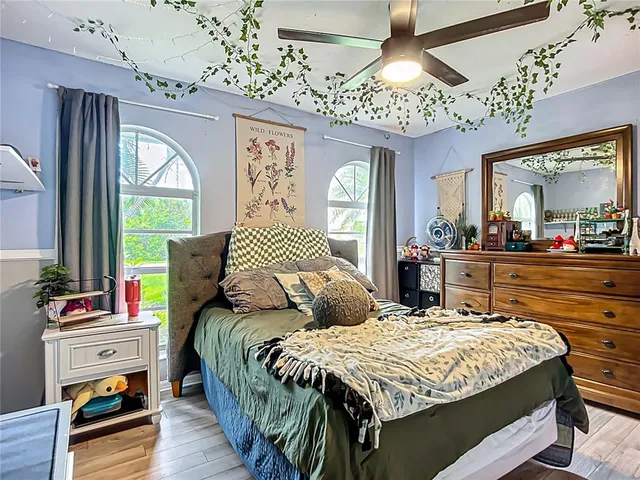 a bedroom with a bed a flat screen tv and a chandelier