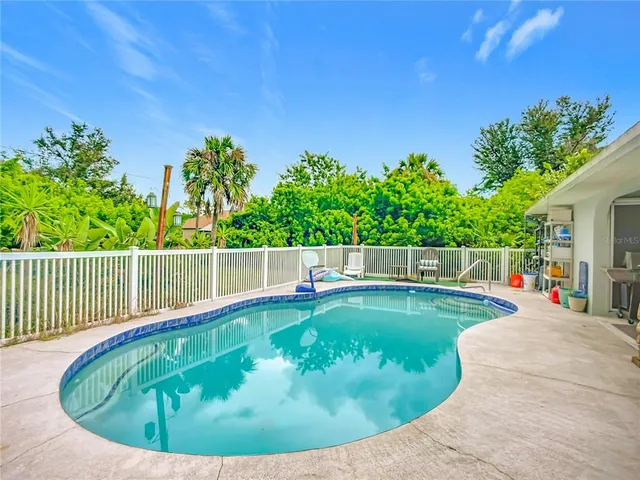 an aerial view of a house with a yard patio and swimming pool