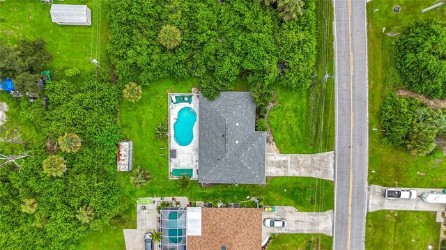 an aerial view of residential houses with outdoor space and trees