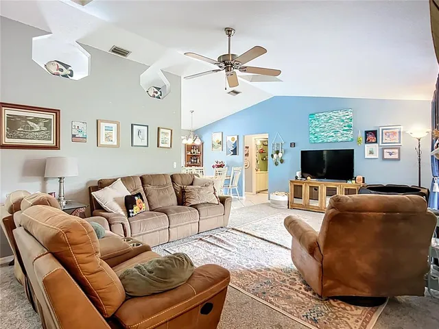 a living room with furniture kitchen view and a flat screen tv