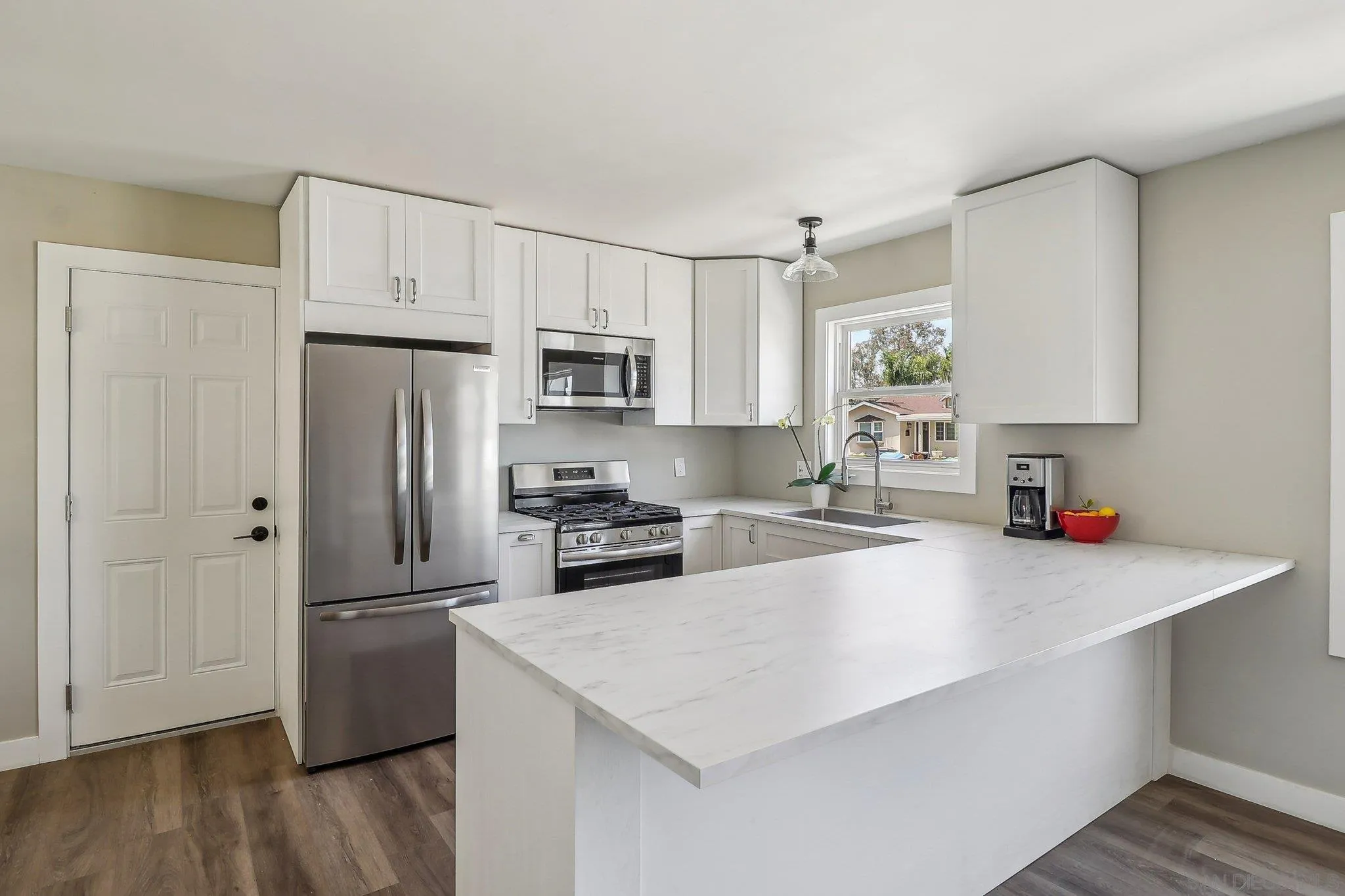 9055 Gorge Avenue Santee, CA 92071 - Photo 8 of 28 a kitchen with a refrigerator a stove a sink dishwasher and white cabinets with wooden floor