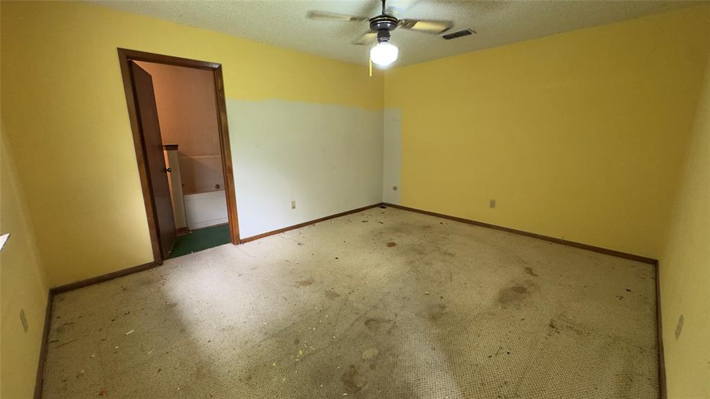 415 Meadowlark Trail Springtown, TX 76082 - Photo 14 of 35 a view of a room with a empty space and a ceiling fan
