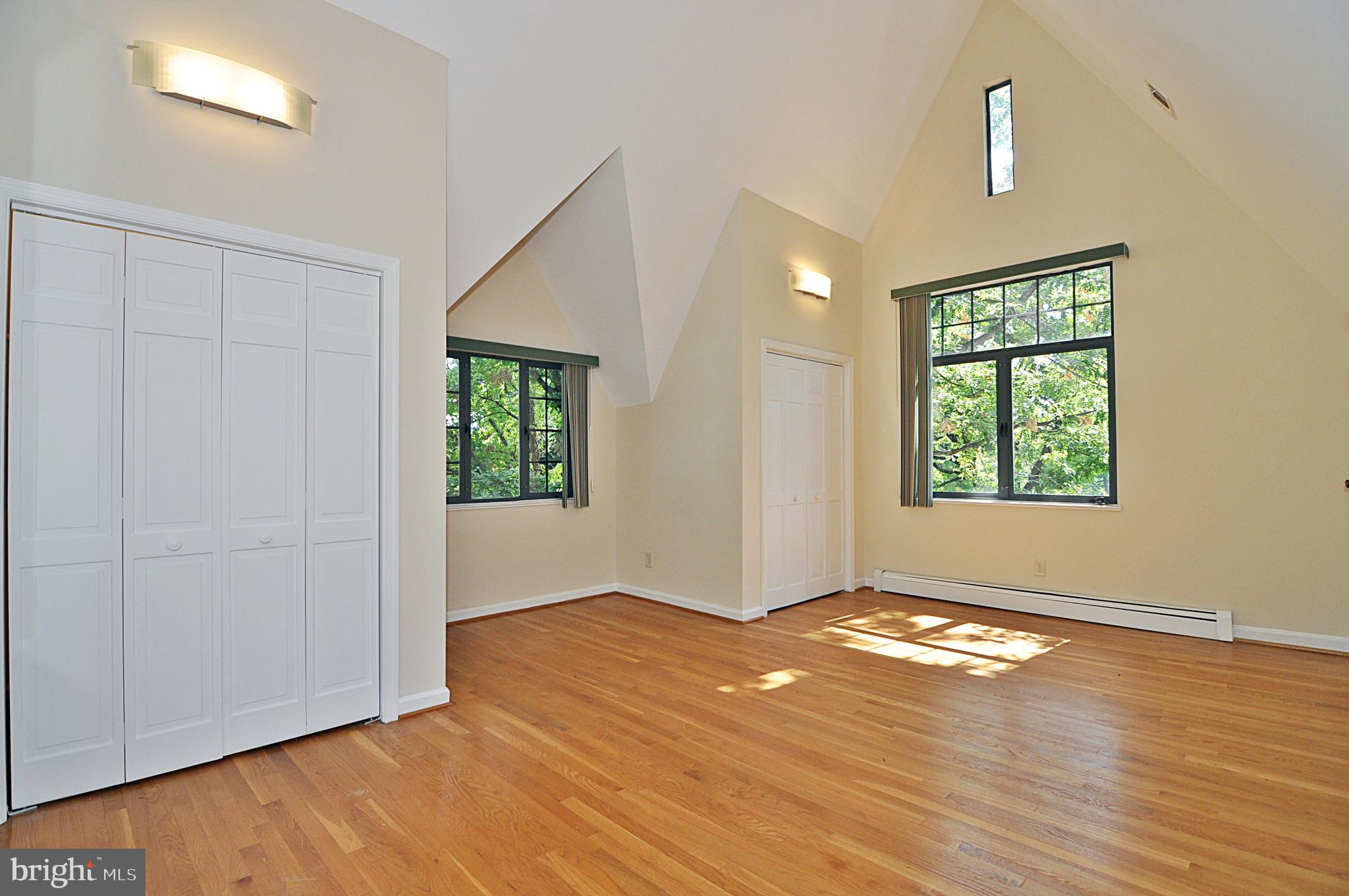 2721 South Arlington Ridge Road Arlington, VA 22202 - Photo 21 of 33 an empty room with wooden floor chandelier fan and windows