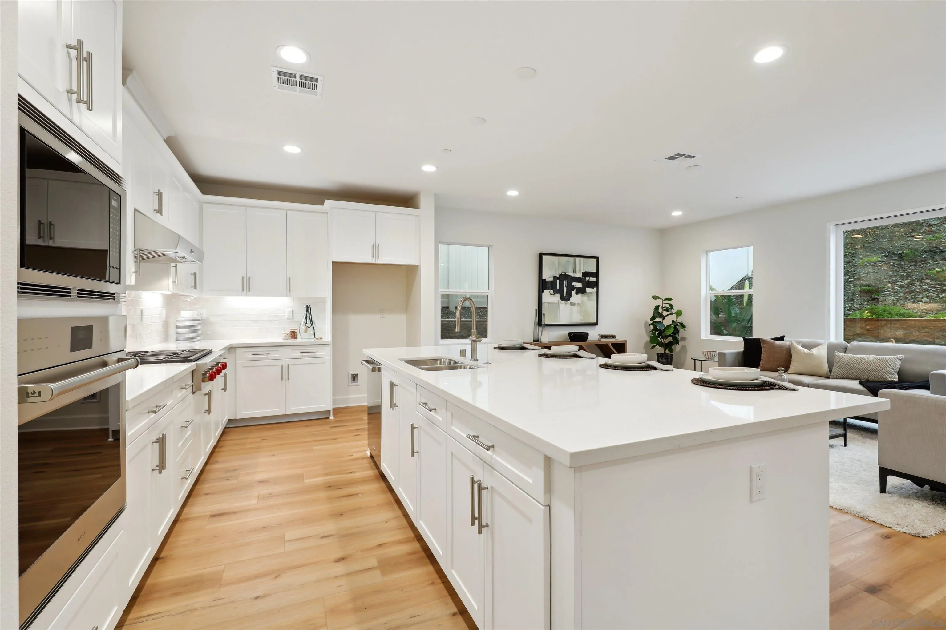 929 Woodhaven Road San Marcos, CA 92069 - Photo 11 of 36 a large white kitchen with a stove top oven a sink a counter space and cabinets