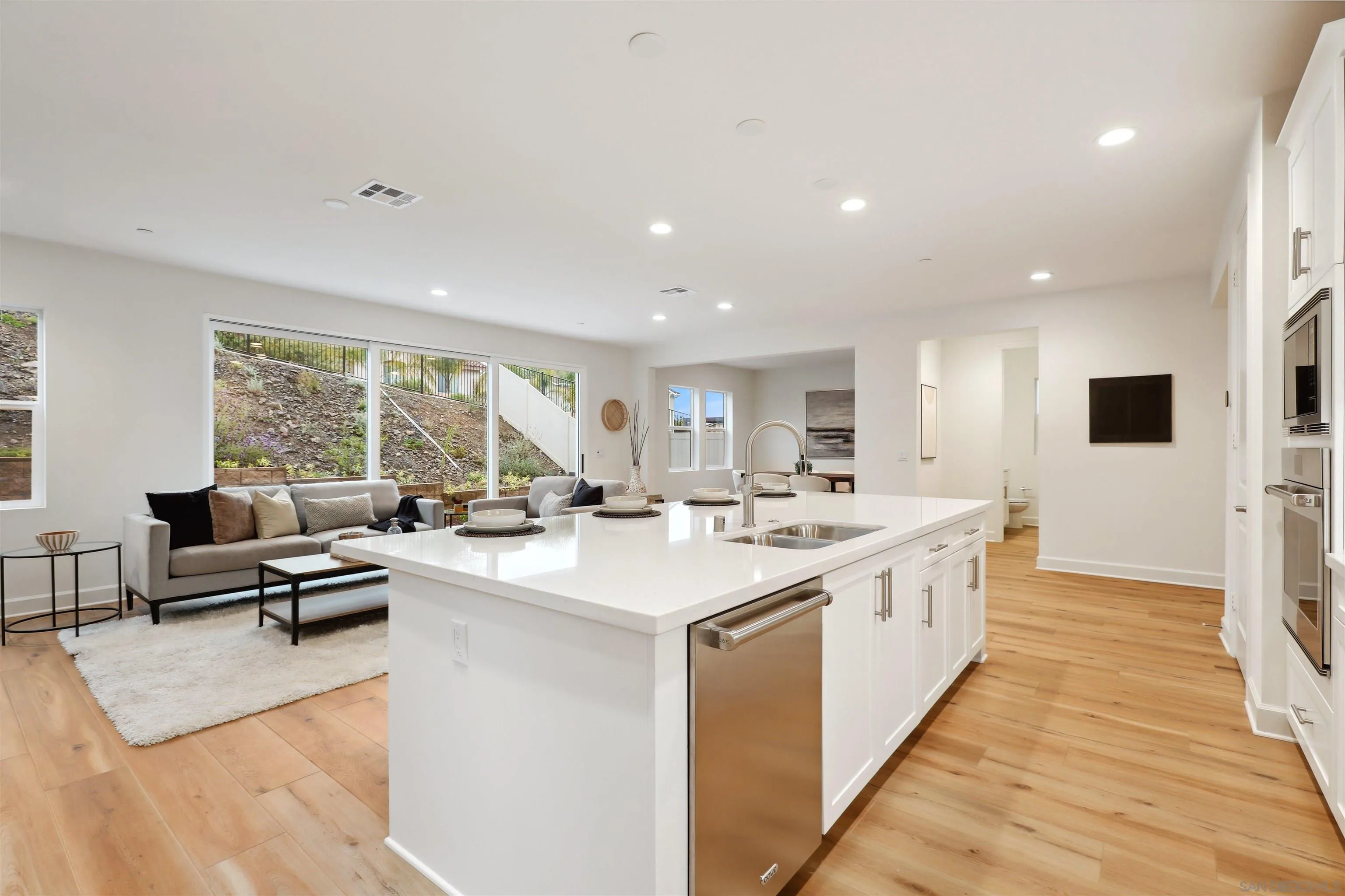 929 Woodhaven Road San Marcos, CA 92069 - Photo 12 of 36 a large white kitchen with a large window and stainless steel appliances