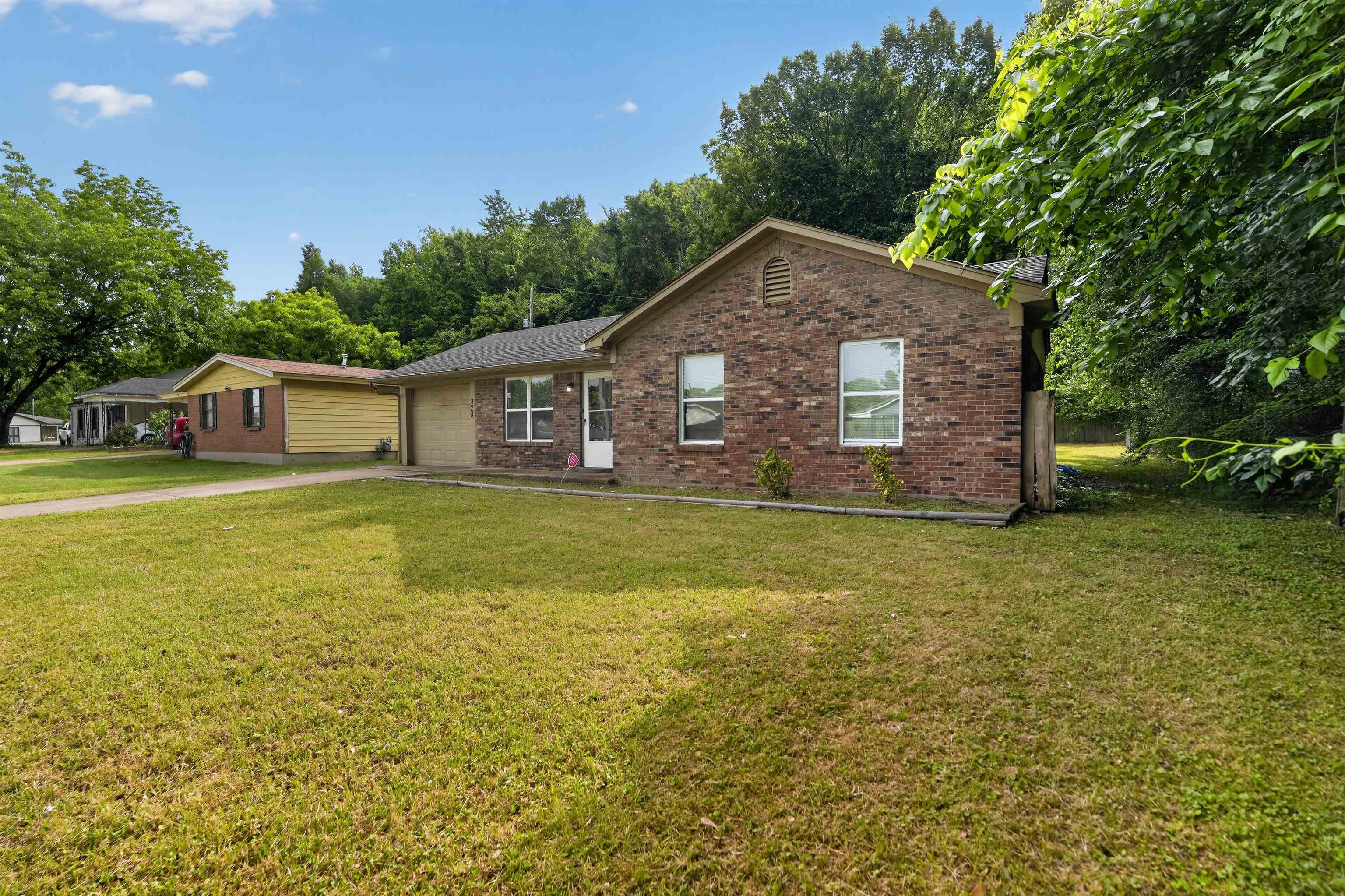3608 Cane Ridge Drive Memphis, TN 38109 - Photo 4 of 31 Brick exterior featuring multiple windows and an attached garage