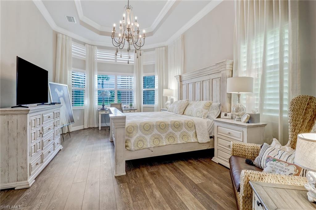 4663 Azalea Drive Naples, FL 34119 - Photo 16 of 34 a bedroom with furniture fireplace and flat screen tv