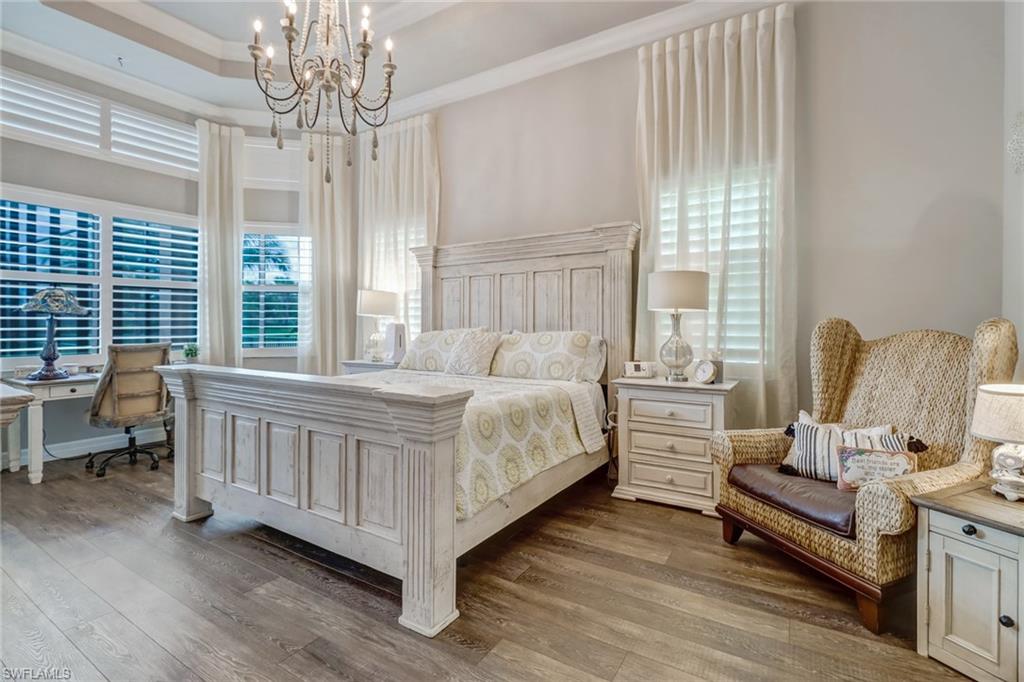 4663 Azalea Drive Naples, FL 34119 - Photo 17 of 34 a bedroom with a bed and a chandelier