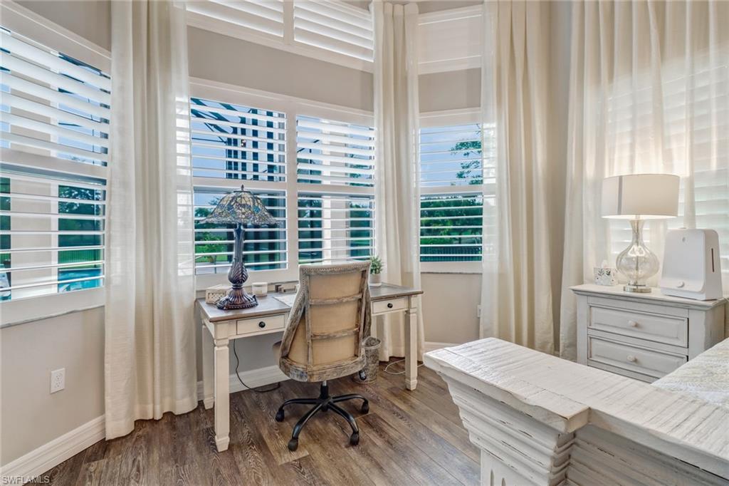 4663 Azalea Drive Naples, FL 34119 - Photo 18 of 34 a bedroom with a bed a table and a window