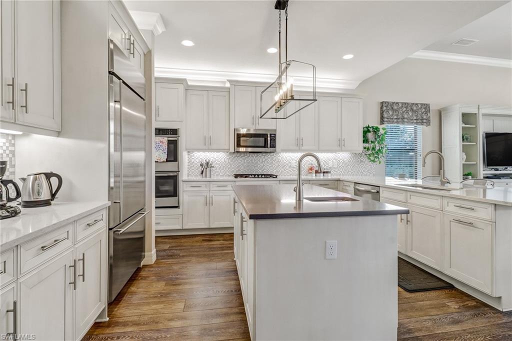 4663 Azalea Drive Naples, FL 34119 - Photo 9 of 34 a kitchen with stainless steel appliances granite countertop a sink a stove and a refrigerator