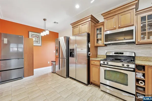 a kitchen with stainless steel appliances granite countertop a refrigerator stove and microwave