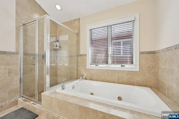 a bathroom with a tub a sink and a shower