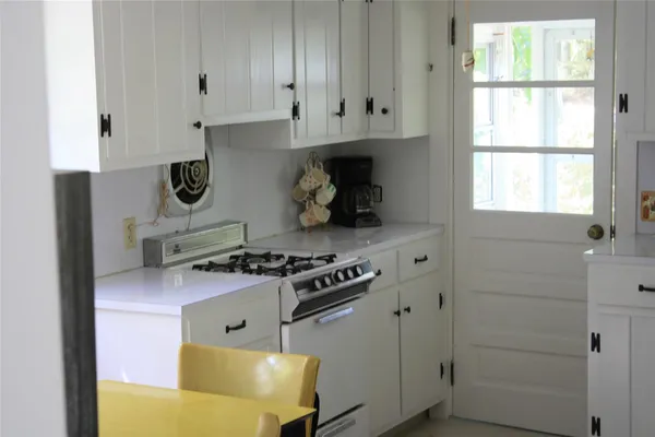 a kitchen with stainless steel appliances granite countertop white cabinets and a stove