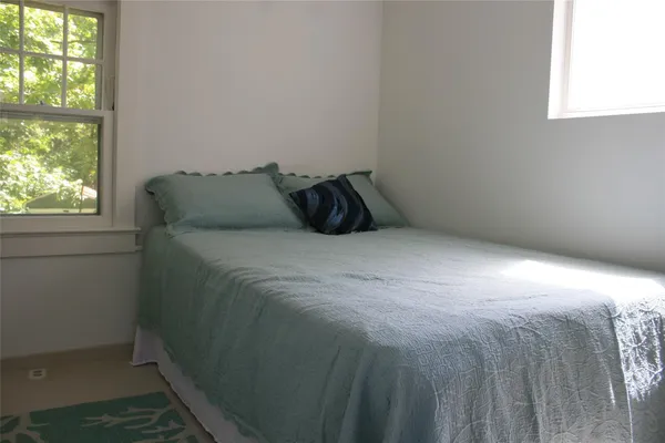 a bed sitting in a bedroom next to a window