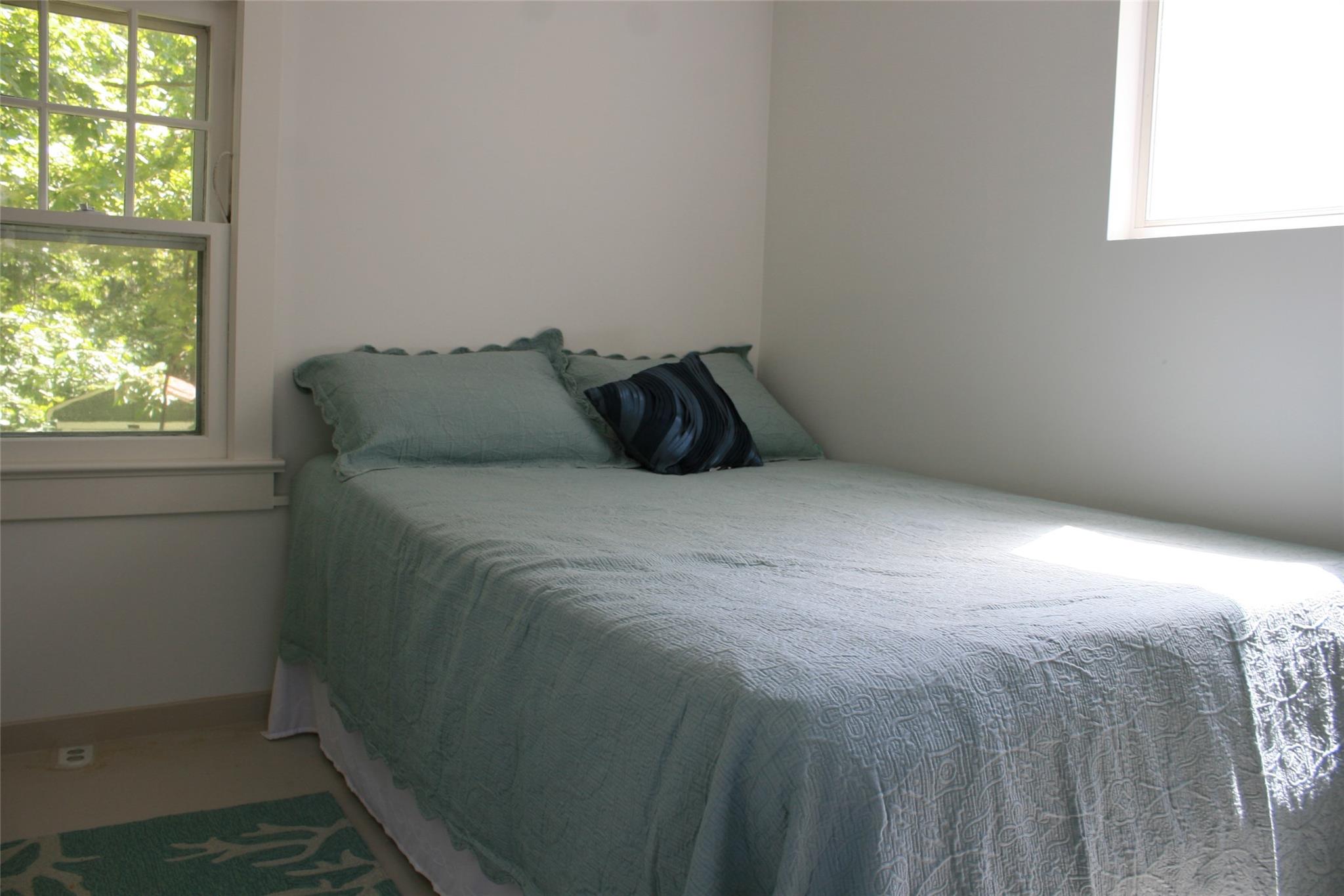 275 Hamilton Avenue Cutchogue, NY 11935 - Photo 7 of 17 a bed sitting in a bedroom next to a window