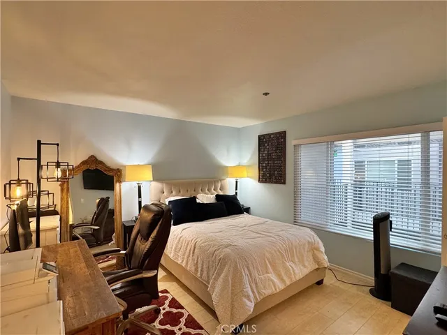 a bedroom with a bed and a table with the outer view