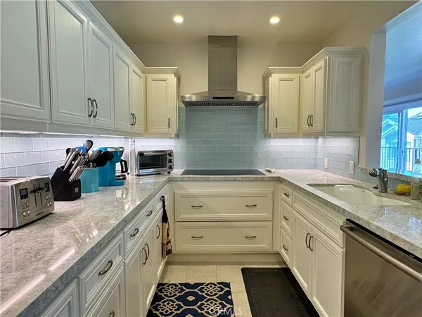a kitchen with granite countertop a sink stainless steel appliances and cabinets