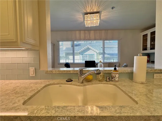 a view of a kitchen with kitchen island a window a sink and a counter space