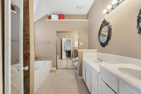 a bathroom with a sink a mirror a vanity and bathtub