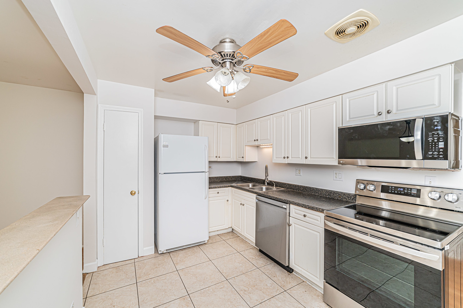 714 East Algonquin Road, Unit J101 Arlington Heights, IL 60005 - Photo 13 of 28 a kitchen with stainless steel appliances a stove a microwave and white cabinets