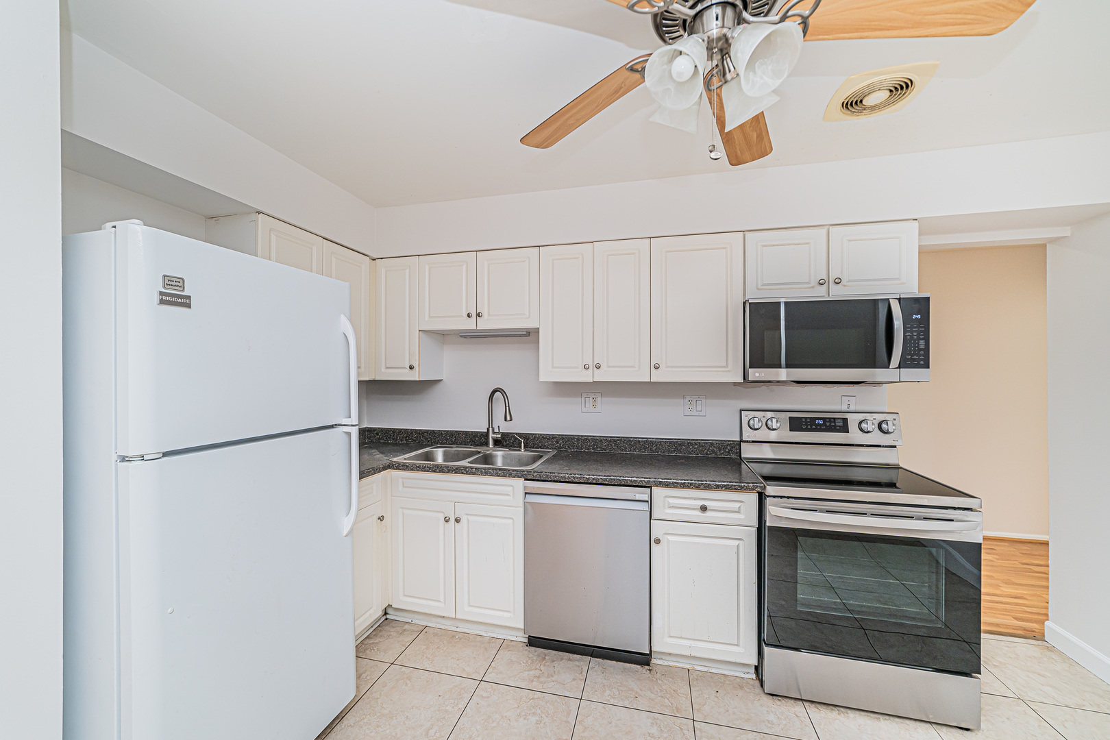 714 East Algonquin Road, Unit J101 Arlington Heights, IL 60005 - Photo 15 of 28 a white kitchen with granite countertop stainless steel appliances and white cabinets