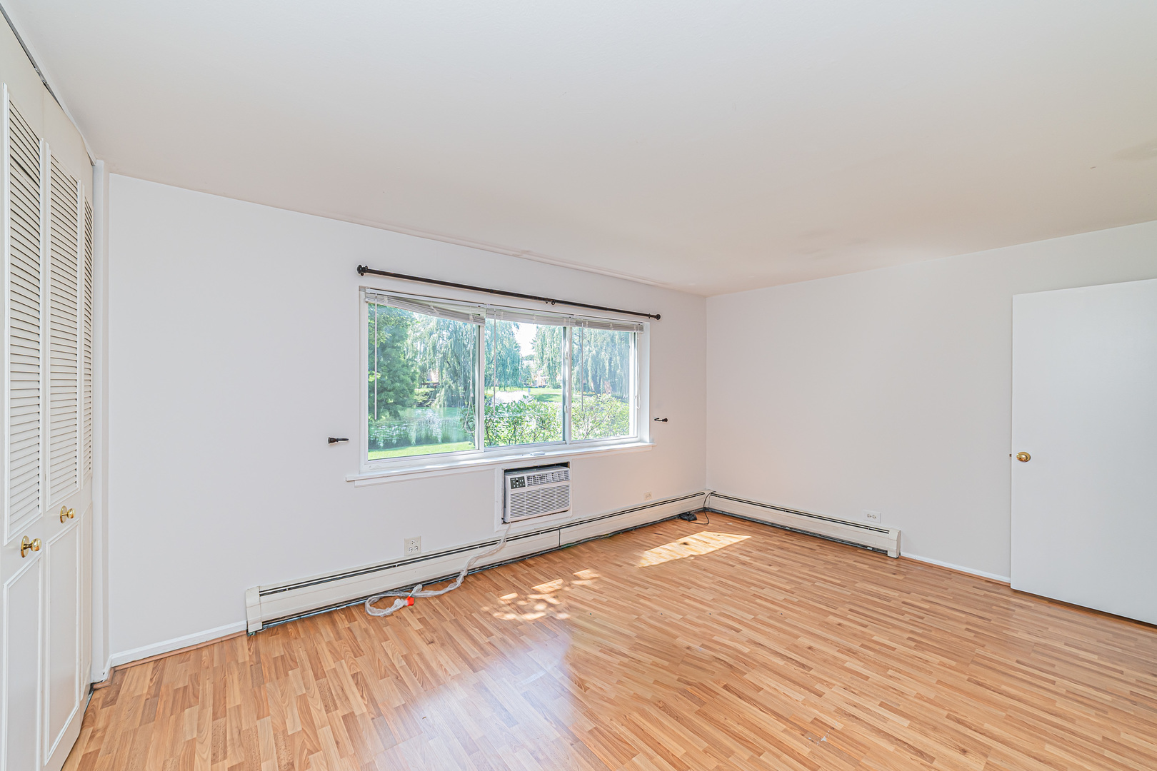 714 East Algonquin Road, Unit J101 Arlington Heights, IL 60005 - Photo 18 of 28 an empty room with wooden floor and windows