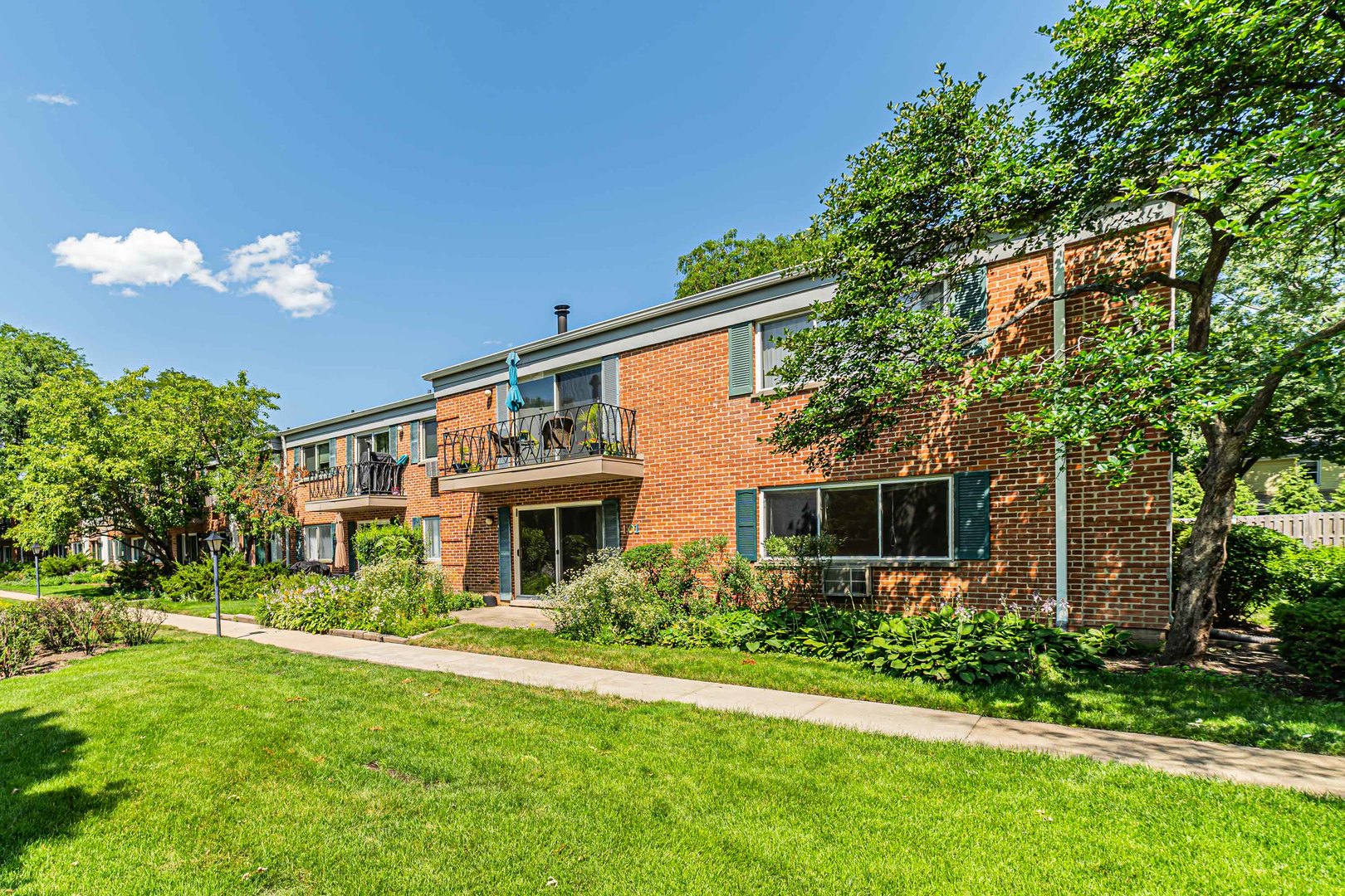 714 East Algonquin Road, Unit J101 Arlington Heights, IL 60005 - Photo 2 of 28 a front view of a house with garden