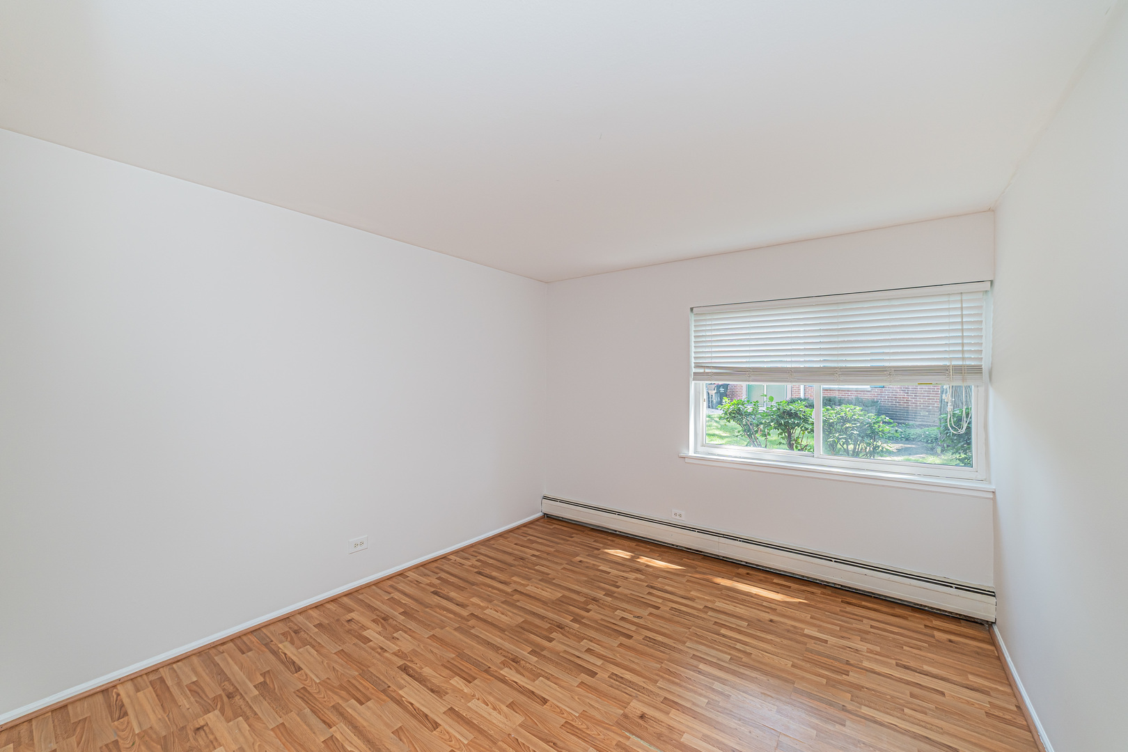 714 East Algonquin Road, Unit J101 Arlington Heights, IL 60005 - Photo 21 of 28 an empty room with wooden floor and windows