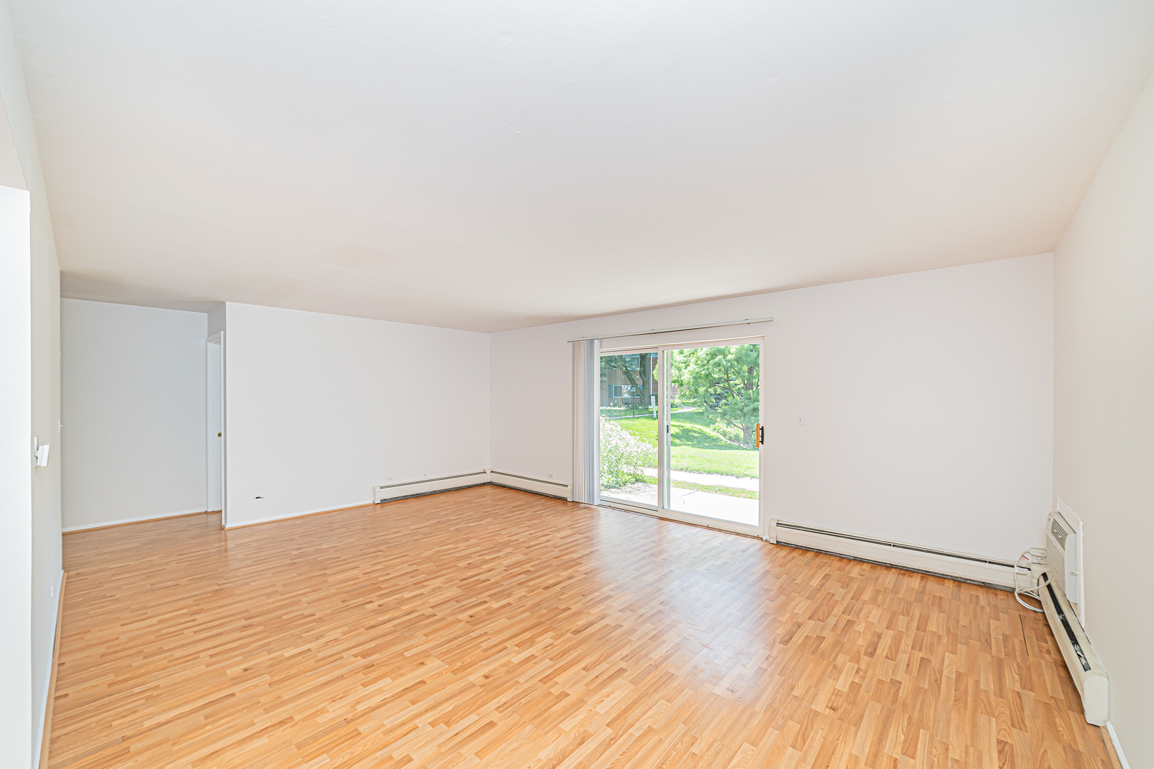 714 East Algonquin Road, Unit J101 Arlington Heights, IL 60005 - Photo 5 of 28 an empty room with wooden floor and windows