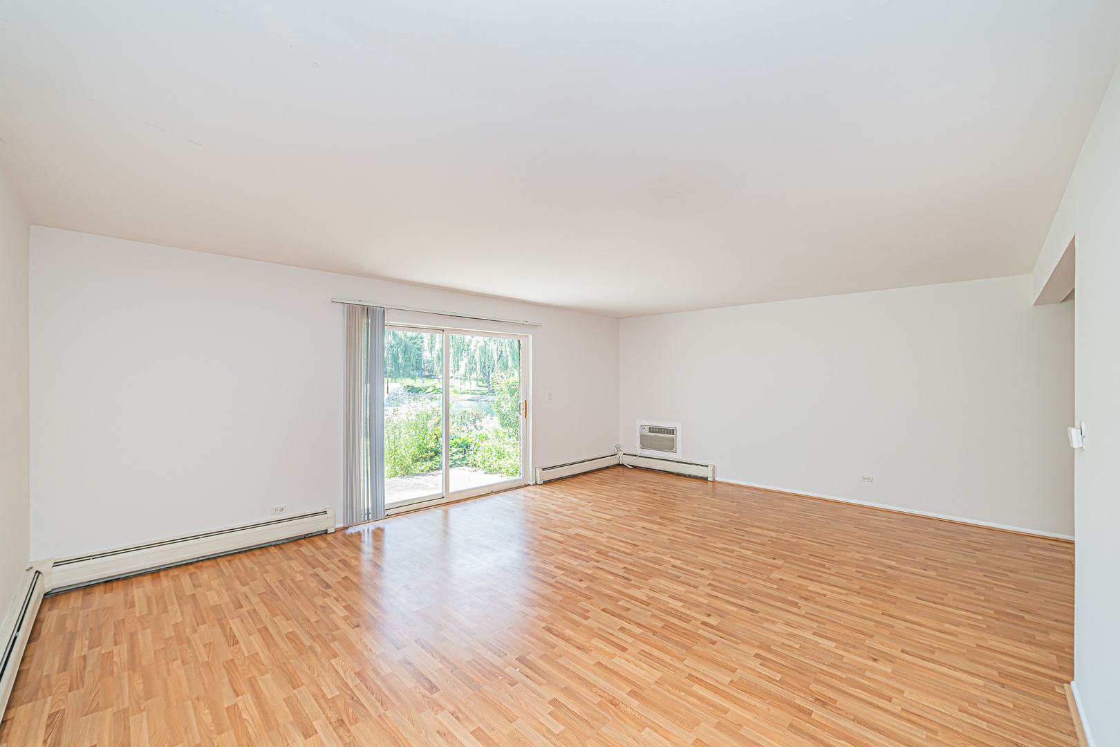 714 East Algonquin Road, Unit J101 Arlington Heights, IL 60005 - Photo 6 of 28 an empty room with wooden floor and windows