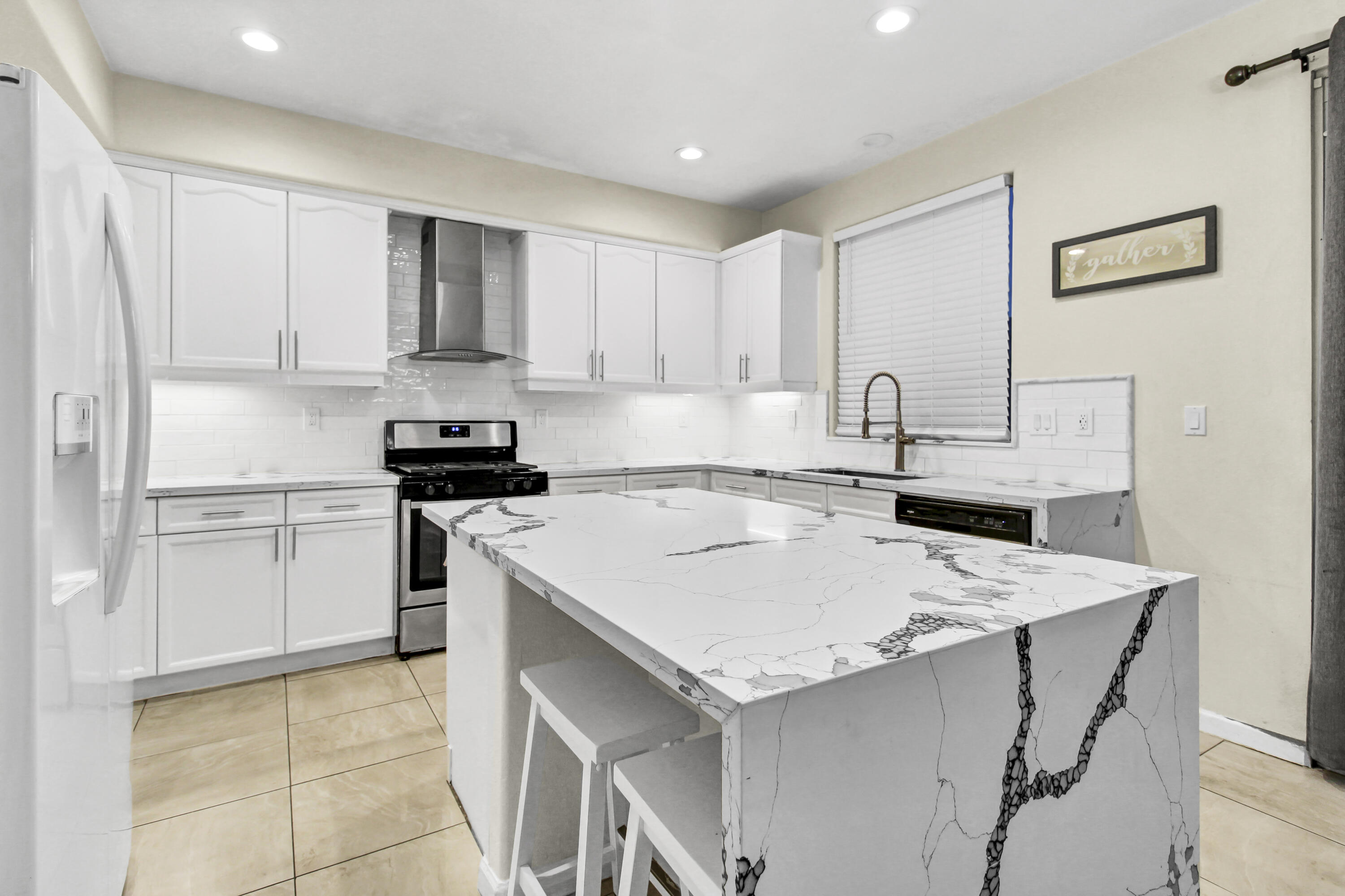 82949 Corte Lucia Indio, CA 92201 - Photo 2 of 36 a kitchen with a sink a stove a refrigerator and white cabinets
