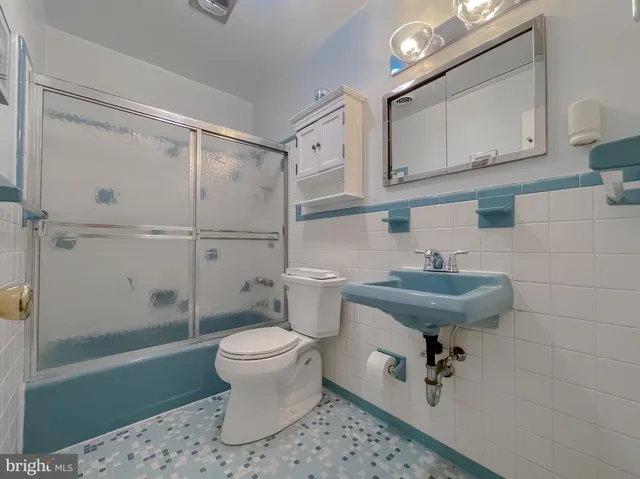 a bathroom with a sink a toilet and mirror