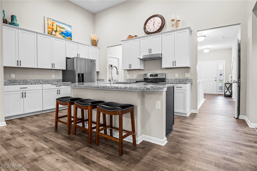 6824 Hatching Way North Ridgeville, OH 44039 - Photo 2 of 42 Kitchen with white cabinetry, stainless steel refrigerator with ice dispenser, a center island with sink, range, and dark hardwood / wood-style flooring
