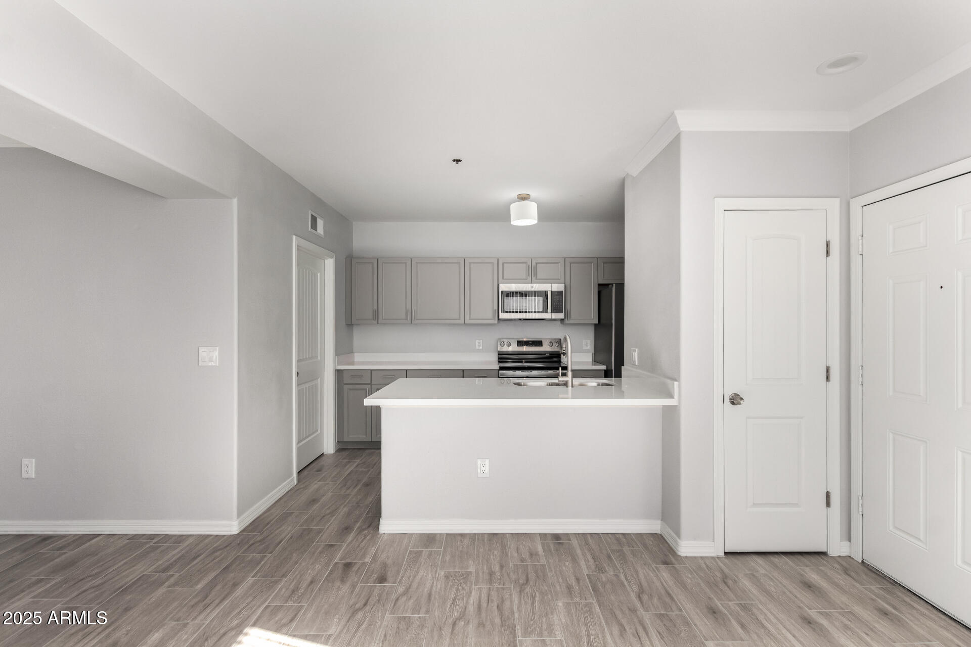 2134 East Broadway Road, Unit 1035 Tempe, AZ 85282 - Photo 13 of 31 a living room with stainless steel appliances a wooden floor a large window and a sink