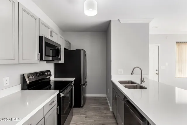 a kitchen with stainless steel appliances granite countertop a sink stove and refrigerator