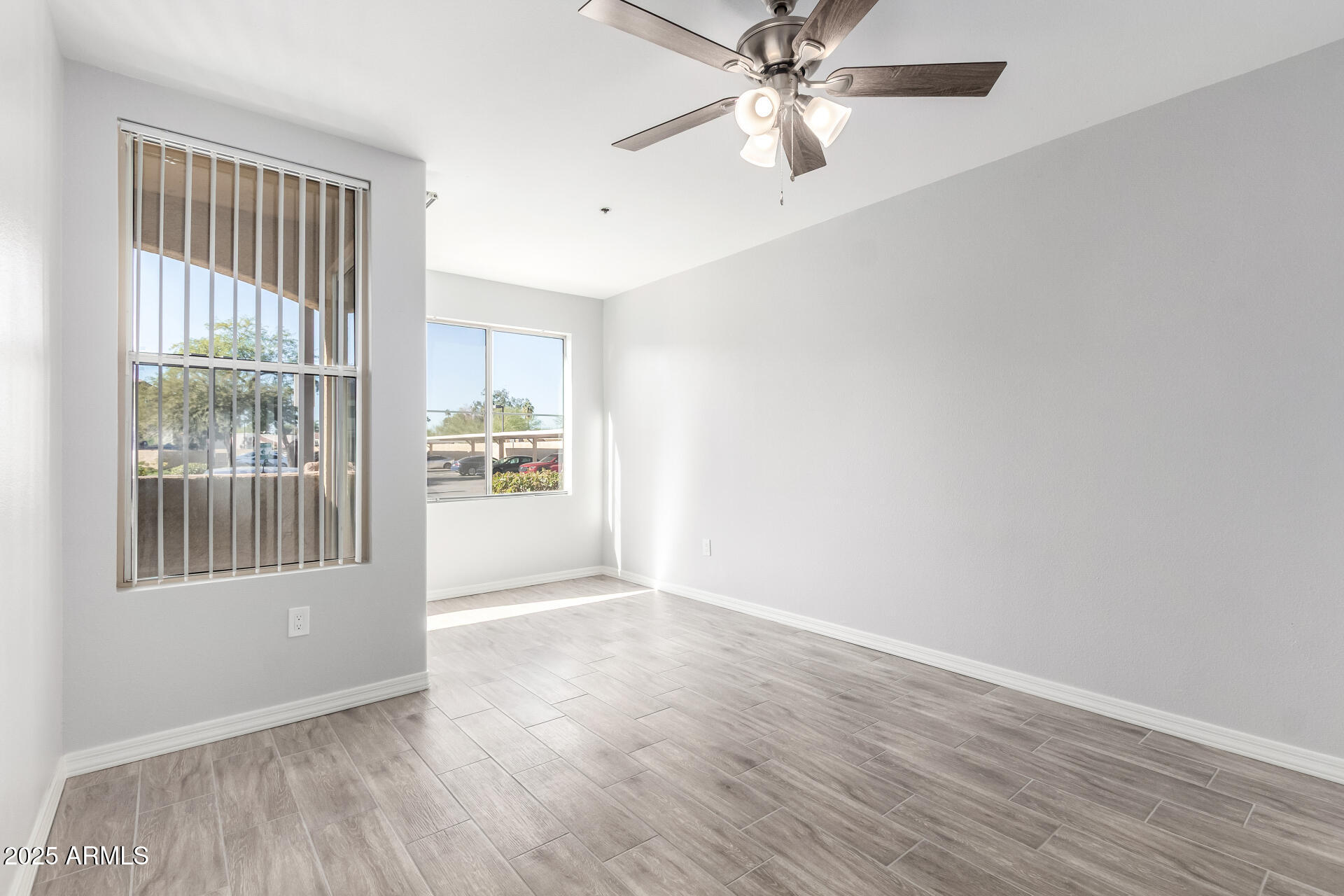 2134 East Broadway Road, Unit 1035 Tempe, AZ 85282 - Photo 17 of 31 an empty room with wooden floor fan and windows