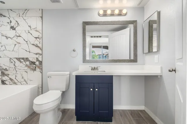 a bathroom with a sink a toilet a mirror and shower