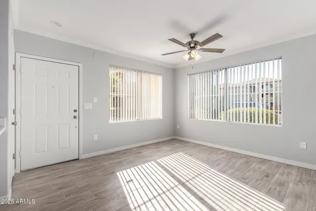 a view of an empty room with a window and wooden floor