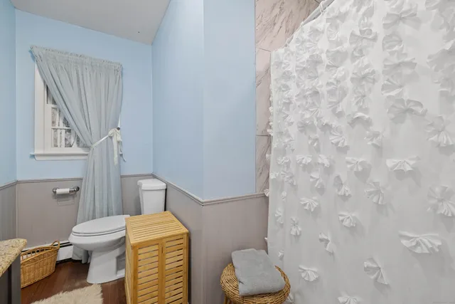 a bathroom with a toilet and a shower curtain
