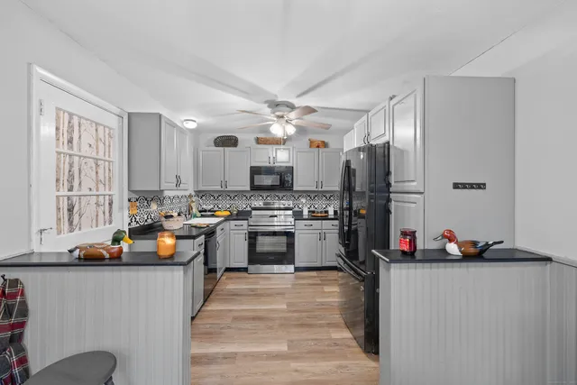 a kitchen view of a counter top space a stove and a refrigerator