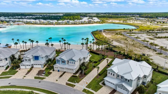 an aerial view of residential houses with outdoor space and lake view